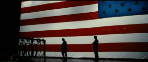 This shot sums up the theme of the film. The shadowy figures who really control politics behind the scenes and do it all under the protection of the American flag (it's in the name of what's best for the country)